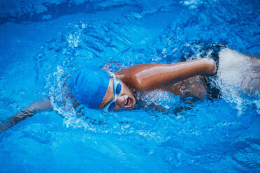 Junge paralympische Schwimmerin beim Kraulen im Schwimmbecken - JCMF00079