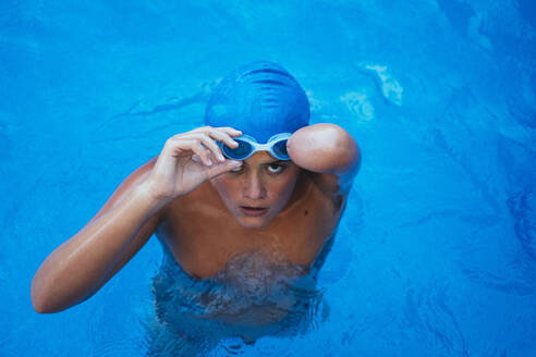 Porträt einer jungen paralympischen Schwimmerin beim Anlegen der Schwimmbrille - JCMF00080