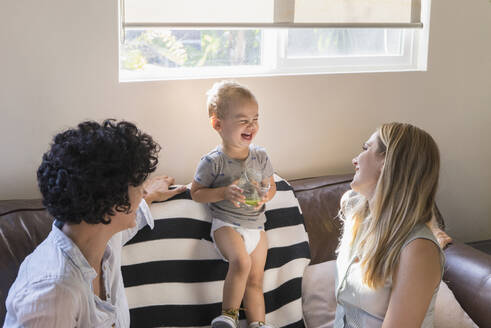 Kaukasische lesbische Mütter lachend mit Babysohn auf dem Sofa - BLEF12157
