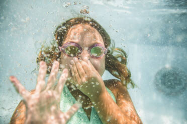 Kaukasisches Mädchen hält Nase unter Wasser im Schwimmbad - BLEF12202