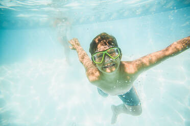 Caucasian boy swimming underwater in swimming pool - BLEF12207