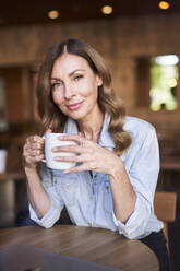 Business woman with a cup of coffee in a cafe - PNEF01749