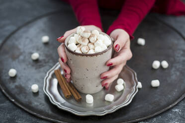 Frauenhände halten eine Tasse mit heißer Schokolade mit Marshmellows - JUNF01703