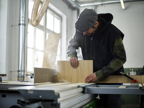 Carpenter sawing wood with circular saw stock photo