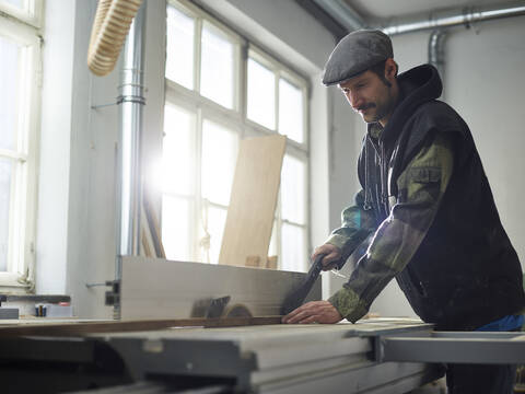 Zimmermann sägt Holz mit Kreissäge, lizenzfreies Stockfoto