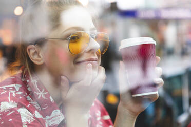 Young woman in a cafe drinking and enjoying a coffee - WPEF01629