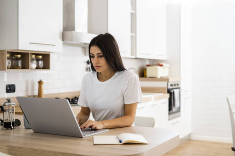 Junge Frau benutzt Laptop zu Hause, lizenzfreies Stockfoto