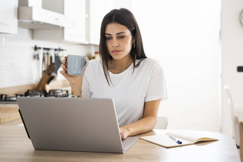 Junge Frau benutzt Laptop zu Hause, lizenzfreies Stockfoto