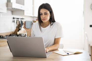 Young woman using laptop at home - GIOF06931