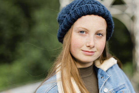 Porträt eines jungen Mädchens mit Wollmütze, das in die Kamera schaut, lizenzfreies Stockfoto