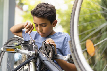 Junge repariert sein Fahrrad - DIGF07721