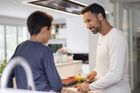 Vater und Sohn kochen gemeinsam in der Küche zu Hause - DIGF07739
