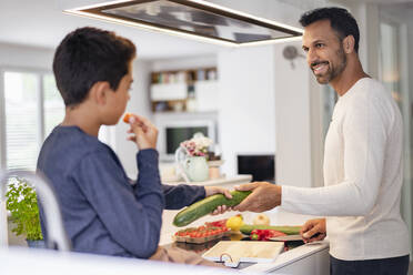 Father and son cooking in kitchen at home together - DIGF07740