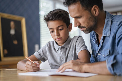 Vater hilft Sohn bei den Hausaufgaben - DIGF07743