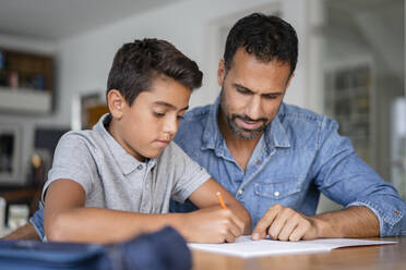 Vater hilft Sohn bei den Hausaufgaben - DIGF07745