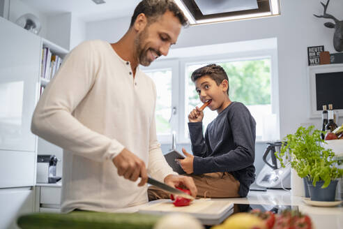 Vater und Sohn kochen gemeinsam in der Küche zu Hause - DIGF07773