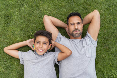 Father and son lying in grass together - DIGF07799