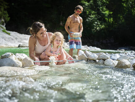 Familie mit Tochter repariert Wasserrad in einem Gebirgsbach - CVF01364