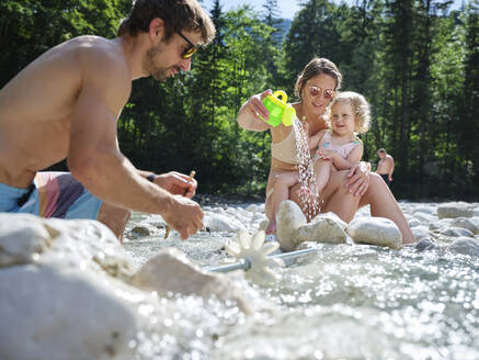 Familie mit Tochter repariert Wasserrad in einem Gebirgsbach - CVF01377