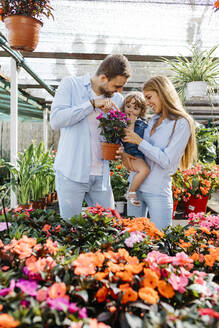 Glückliche Mutter, Vater und Tochter kaufen Blumen in einem Gartencenter - JRFF03479