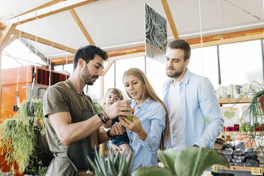 Verkäuferin in einem Gartencenter, die Kunden berät - JRFF03487