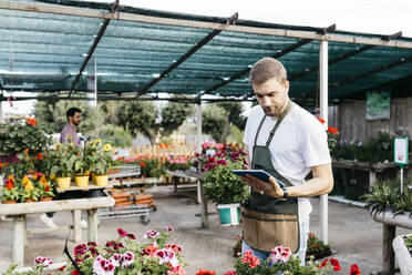 Arbeiter in einem Gartencenter mit einem Tablet - JRFF03515