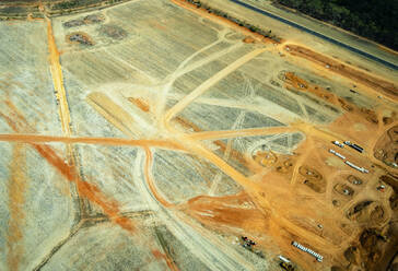 Luftaufnahme eines Steinbruchs mit Lastwagen, die orangefarbenen Sand in Queensland, Australien, transportieren - GEMF03008