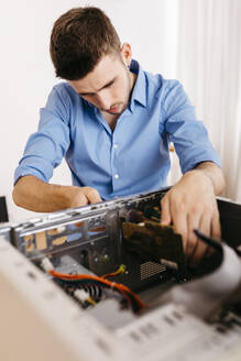 Techniker, der einen Desktop-Computer repariert und die Leiterplatte austauscht - JRFF03551
