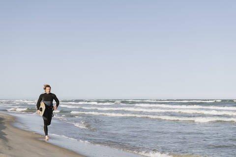 Surfer beim Laufen am Strand, lizenzfreies Stockfoto