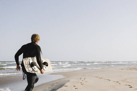 Surfer beim Laufen am Strand, lizenzfreies Stockfoto