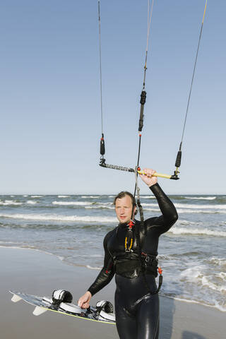 Kiteboarder mit seinem Lenkdrachen am Strand, lizenzfreies Stockfoto