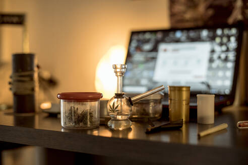 Marihuana in einem Glas, mit Haschpfeife und Joint auf dem Tisch - ACPF00566