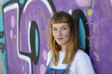 Junge Frau vor einem lila Graffiti - FLLF00253