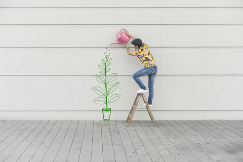 Digitales Komposit eines jungen Mannes, der eine Blume an einer Mauer gießt, lizenzfreies Stockfoto