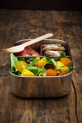 Nahaufnahme eines gesunden vegetarischen Essens in einer Lunchbox auf einem Holztisch - LVF08218