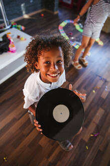 Porträt eines glücklichen jungen DJs mit Schallplatte - LJF00556