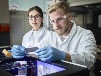 Two technicians working on solar cell in lab - CVF01380