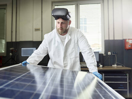 Technician with VR glasses controlling solar panel in lab - CVF01384