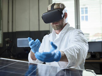Techniker mit VR-Brille und Solarpanel im Labor - CVF01385