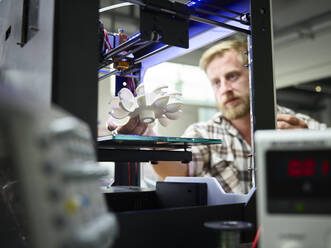 Technician with turbine wheel being printed in 3d printer - CVF01401