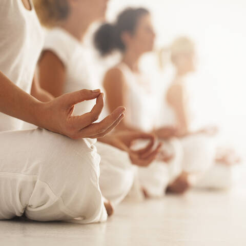 Nahaufnahme einer meditierenden Frau in einer Yogastunde, lizenzfreies Stockfoto