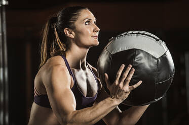 Kaukasischer Athlet, der einen Widerstandsball im Fitnessstudio hebt - BLEF12360