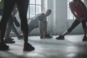 Athleten dehnen ihre Beine im Fitnessstudio - BLEF12367