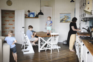 Mother with her three sons in the kitchen - EYAF00314