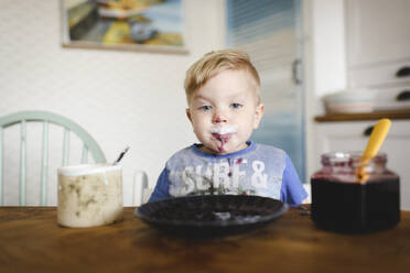 Portrait of cute little boy with blueberry jam in his face - EYAF00327