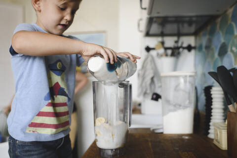 Junge kocht Bananenpfannkuchen in der Küche zu Hause, lizenzfreies Stockfoto