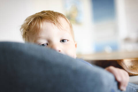 Porträt eines süßen kleinen Jungen auf einem Stuhl, lizenzfreies Stockfoto