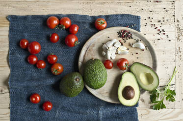 Unmittelbar über der Aufnahme von Avocados mit Tomaten und Gewürzen auf einem Holztisch - ASF06461