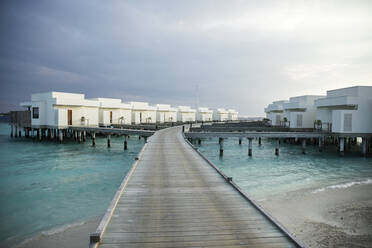 Diminishing perspective of pier leading towards villas over sea at Maldives - CVF01420