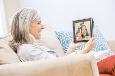 Caucasian grandmother videochatting with granddaughter on digital tablet - BLEF12555